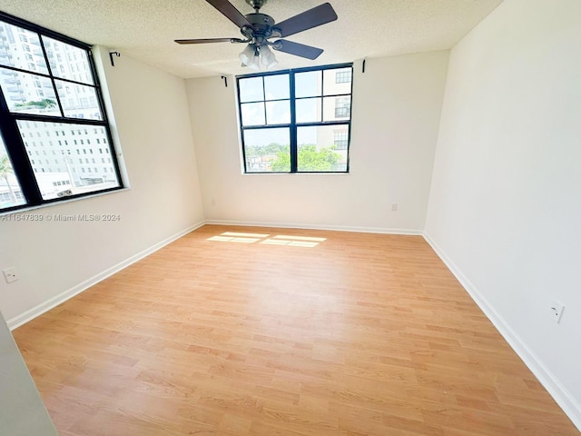 spare room with ceiling fan, a textured ceiling, and light hardwood / wood-style flooring