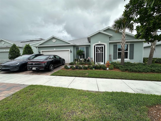 single story home with a garage and a front lawn