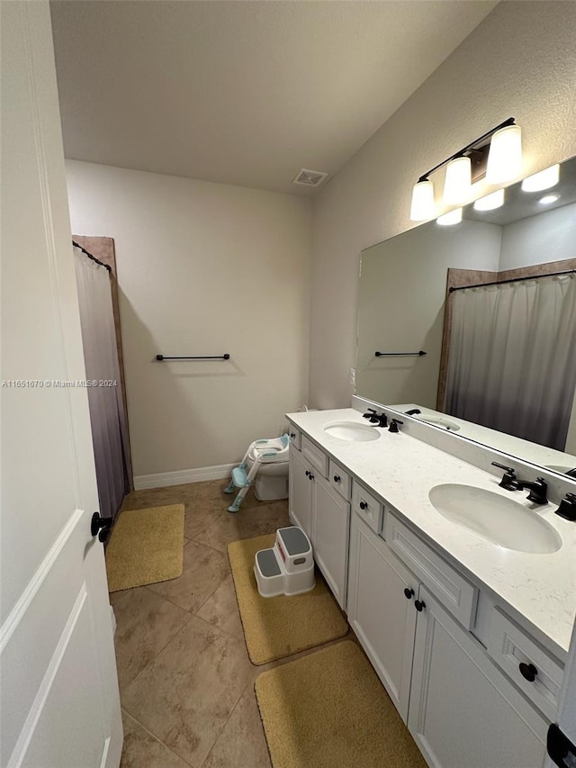 bathroom with vanity, toilet, and tile patterned floors