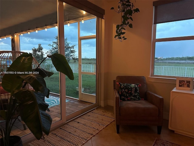 interior space with a wealth of natural light, tile patterned floors, and a water view