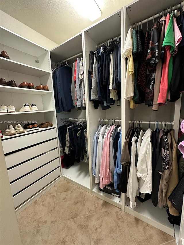 walk in closet with light tile patterned floors