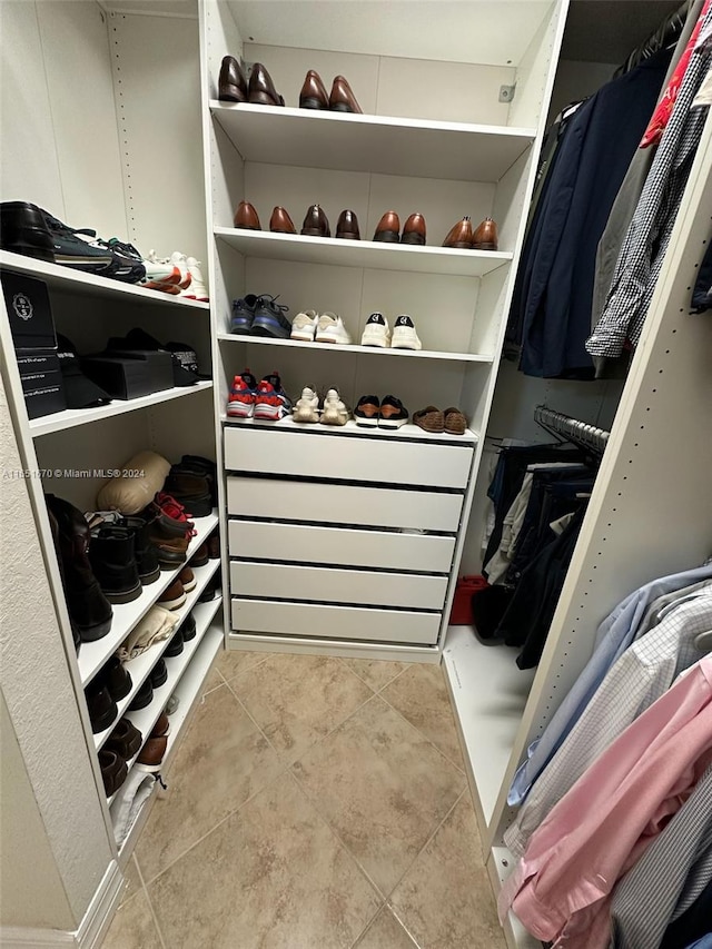 walk in closet with light tile patterned floors