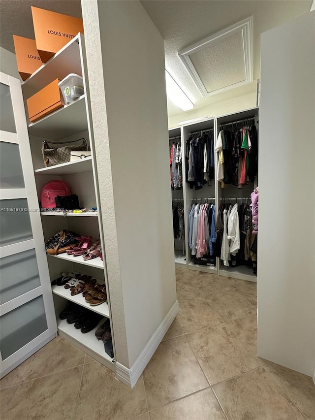 spacious closet with light tile patterned floors