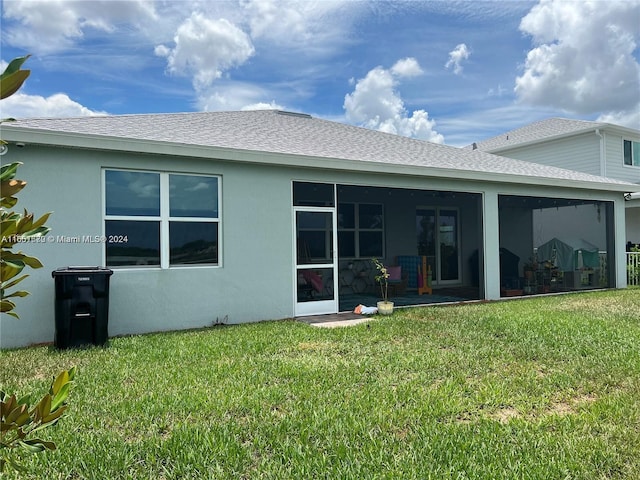 rear view of house with a yard, a patio, and a sunroom