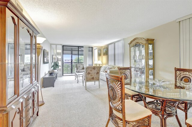 dining area with light colored carpet and a textured ceiling