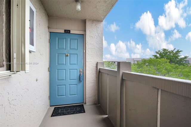 view of exterior entry with a balcony