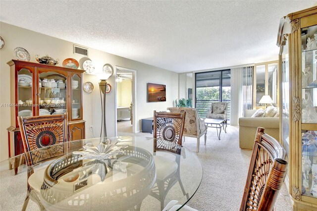 carpeted dining area with a textured ceiling and floor to ceiling windows