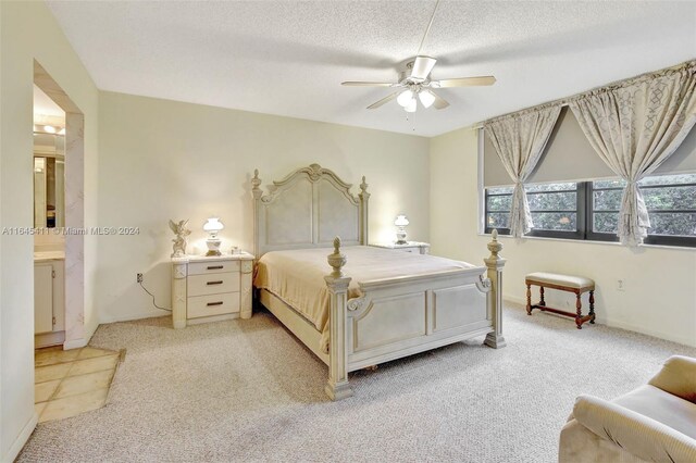 bedroom featuring light carpet, a textured ceiling, ensuite bathroom, and ceiling fan