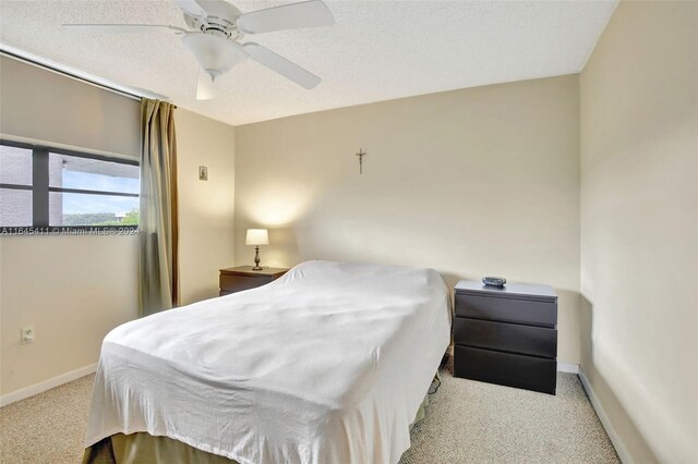 carpeted bedroom featuring a textured ceiling and ceiling fan