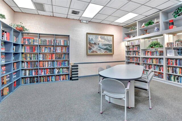 home office with a paneled ceiling and carpet