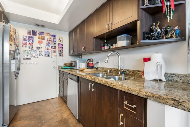 kitchen featuring light stone counters, sink, appliances with stainless steel finishes, and dark brown cabinetry