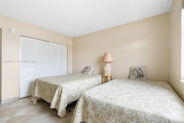 bedroom with a closet and light tile patterned flooring