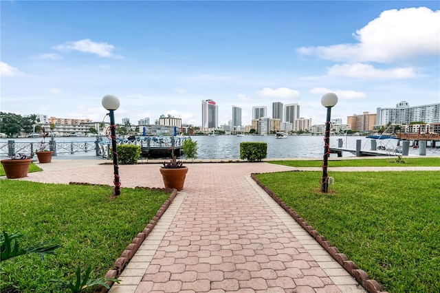 view of property's community featuring a yard and a water view