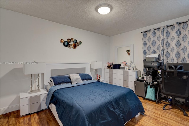 bedroom featuring a textured ceiling and light hardwood / wood-style flooring