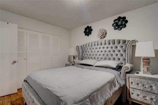 bedroom featuring a closet, wood-type flooring, and a textured ceiling