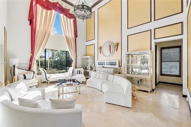 living room with a towering ceiling and a chandelier