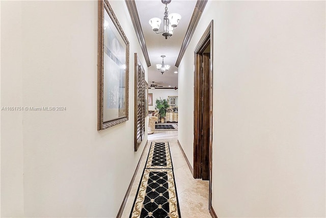 corridor featuring ornamental molding and an inviting chandelier