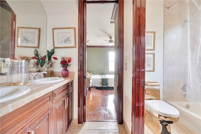 full bathroom with vanity, toilet, ceiling fan, hardwood / wood-style floors, and tiled shower / bath