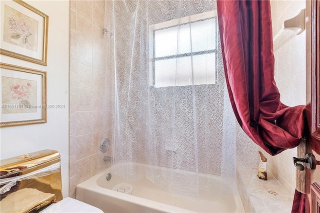 bathroom featuring shower / tub combo and toilet