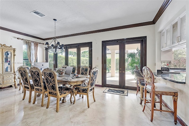 dining space featuring a chandelier, a textured ceiling, french doors, and crown molding