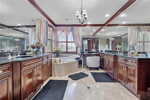 bathroom with a healthy amount of sunlight, tiled bath, an inviting chandelier, and vanity