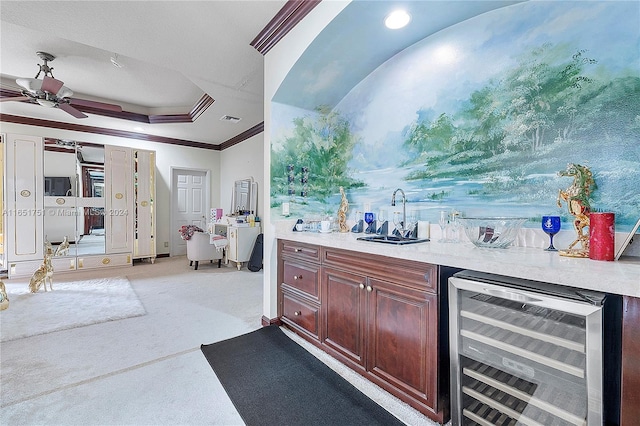 bar with a tray ceiling, sink, beverage cooler, ornamental molding, and ceiling fan