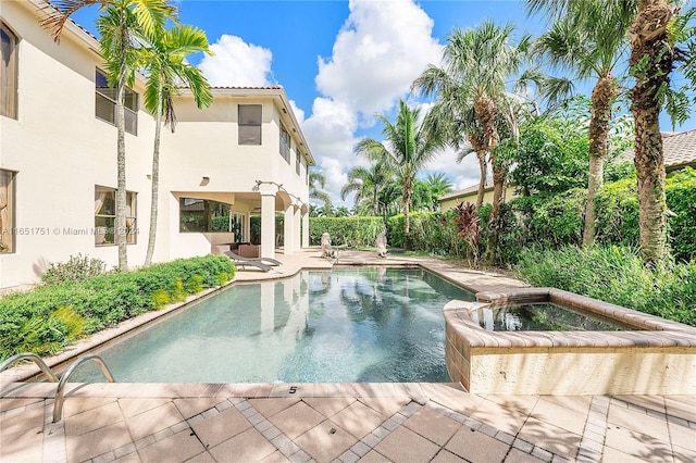 view of pool featuring a patio and an in ground hot tub