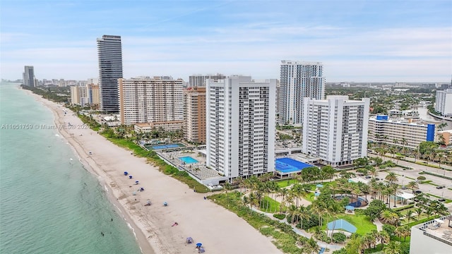 birds eye view of property featuring a water view and a beach view