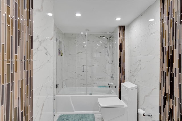 bathroom featuring tile walls, toilet, and enclosed tub / shower combo