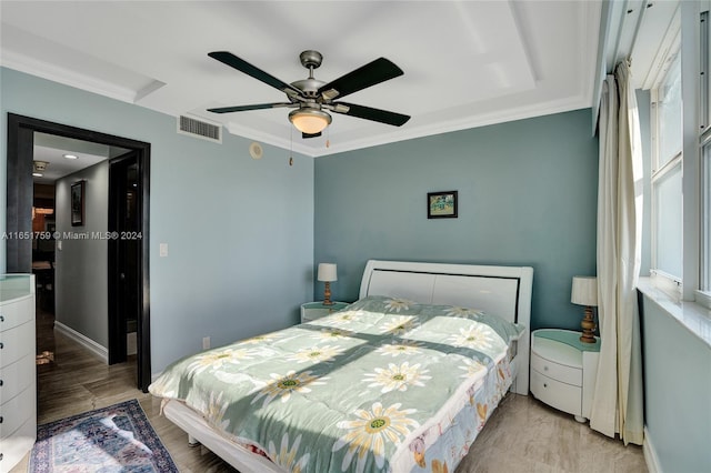 bedroom featuring ceiling fan, ornamental molding, and light hardwood / wood-style flooring