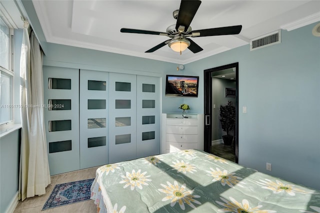 bedroom with crown molding, ceiling fan, and a closet