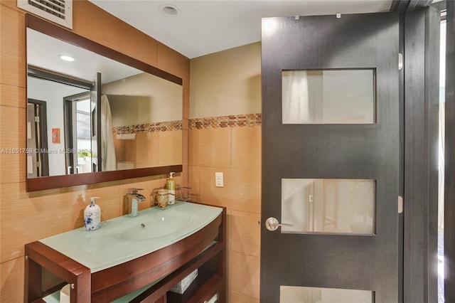 bathroom featuring tile walls and vanity