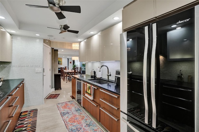 kitchen with black refrigerator, wine cooler, sink, ceiling fan, and decorative backsplash