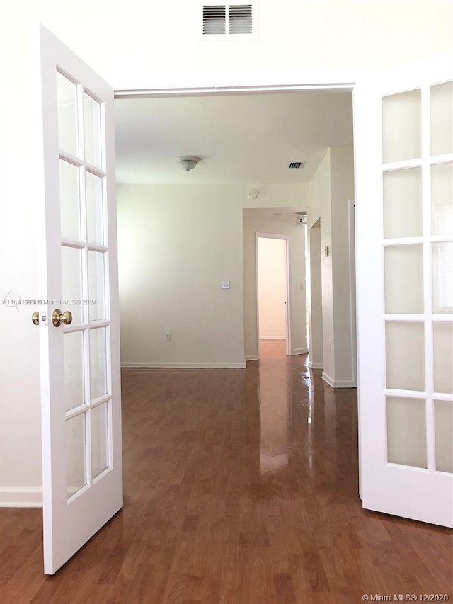hall with dark hardwood / wood-style floors and french doors