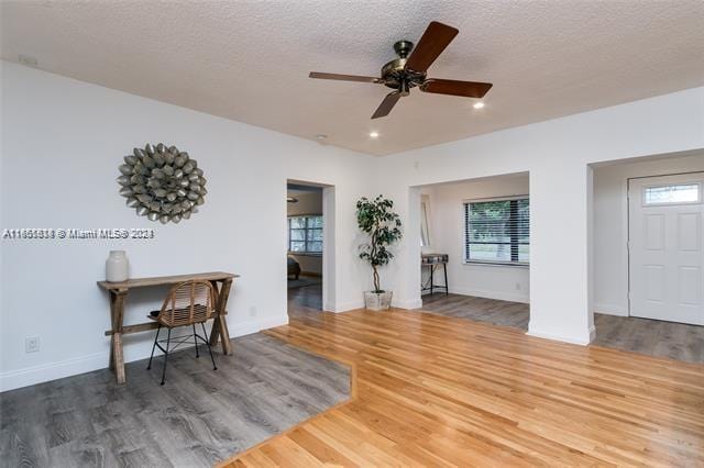 interior space featuring a textured ceiling, wood-type flooring, and ceiling fan