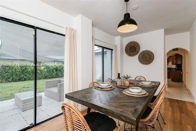 dining room with a textured ceiling and hardwood / wood-style flooring