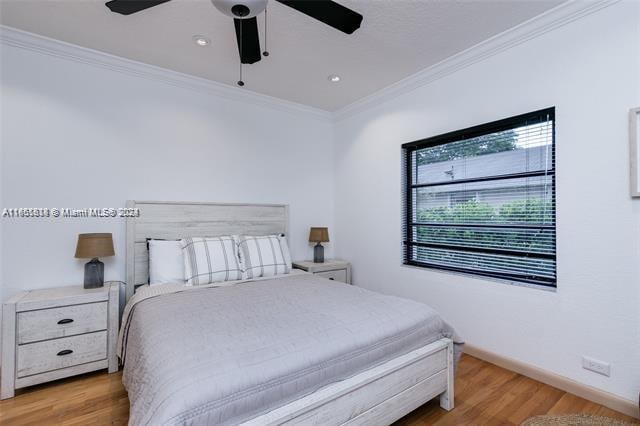 bedroom with ornamental molding, light hardwood / wood-style flooring, and ceiling fan