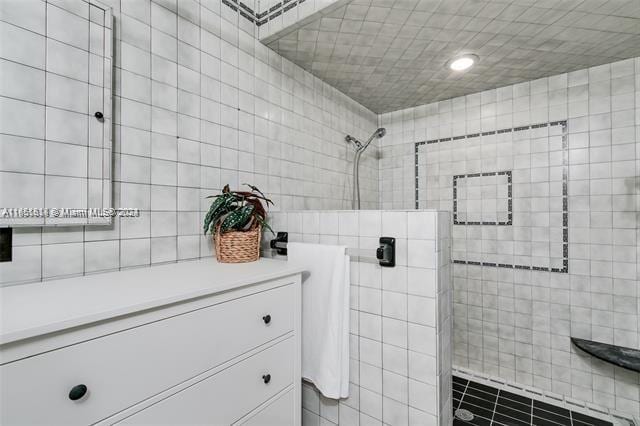 bathroom with vanity, tile walls, and tiled shower