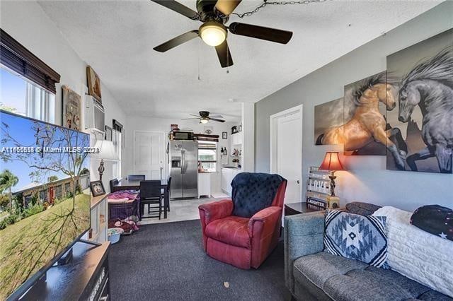 carpeted living room featuring ceiling fan