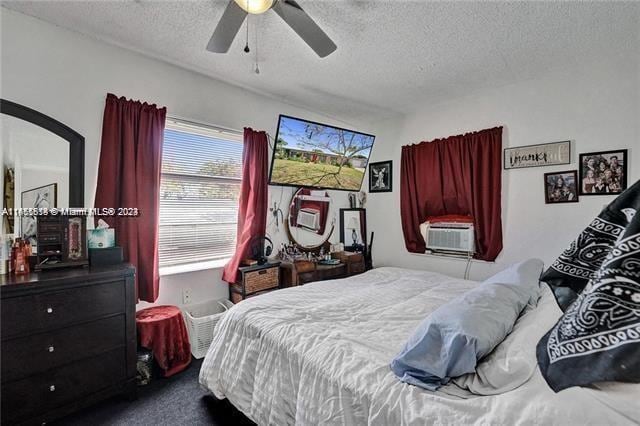 bedroom featuring a textured ceiling, carpet flooring, ceiling fan, and cooling unit