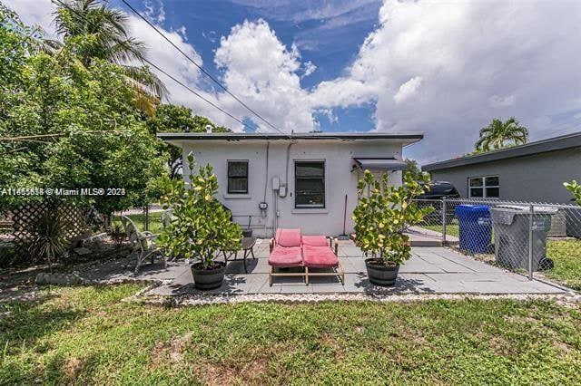 back of property featuring a lawn and a patio area