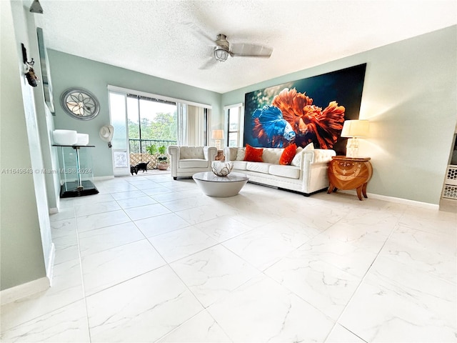 living room with ceiling fan and a textured ceiling