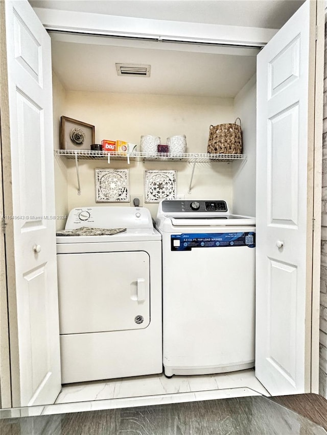 laundry room featuring hardwood / wood-style flooring and washer and clothes dryer