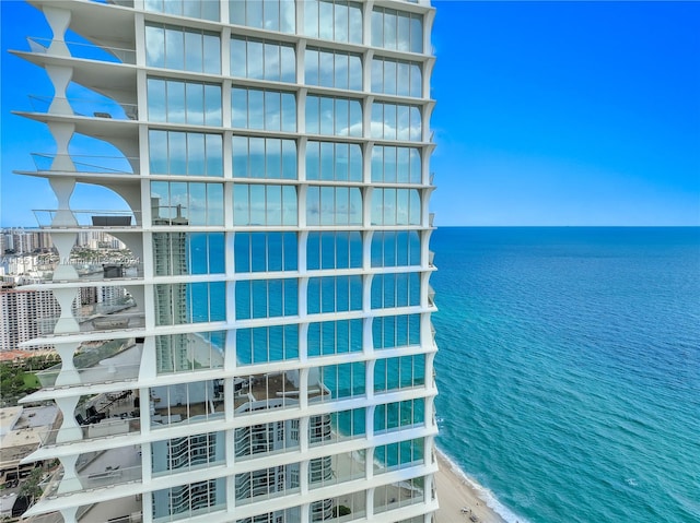 view of building exterior featuring a water view and a view of the beach