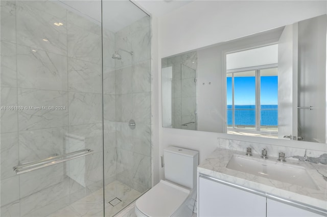 bathroom with a water view, vanity, toilet, and a shower with shower door