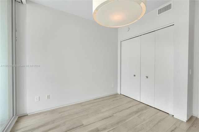 unfurnished bedroom featuring light hardwood / wood-style floors and a closet