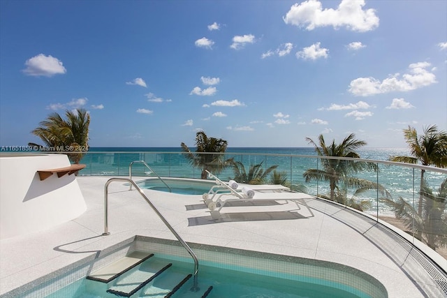 view of pool with an in ground hot tub and a water view