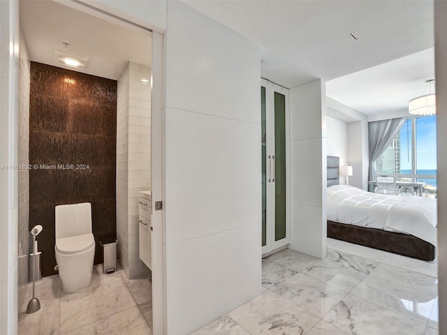 bathroom with a water view, tile walls, toilet, and vanity