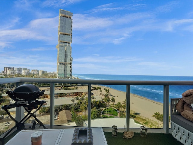 balcony with a grill, a view of the beach, and a water view