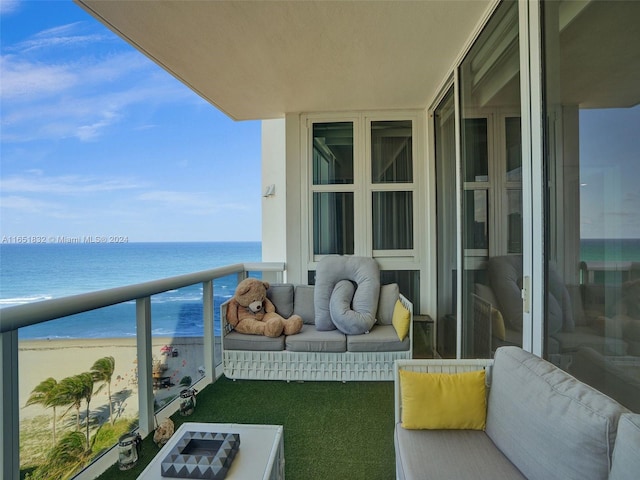 balcony featuring a beach view and a water view